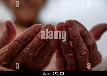 Old woman hands praying for god rising her hands Stock Photo