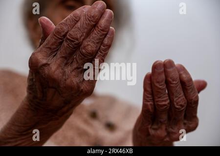 Old woman hands praying for god rising her hands Stock Photo