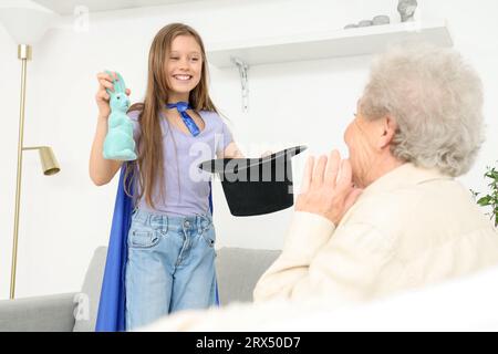 Little magician showing trick to her grandmother at home Stock Photo