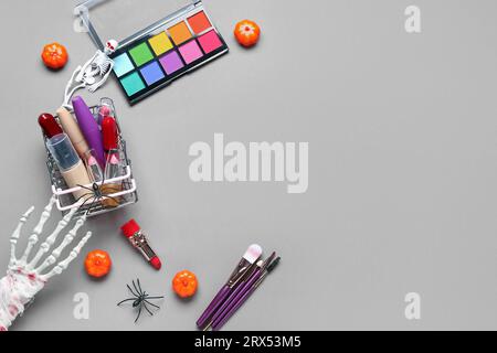Composition with cosmetic products and Halloween decorations on grey background Stock Photo