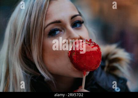 Enjoying a caramel apple, a blonde woman takes in the sumptuous art and architecture that stand as hallmarks of Western civilization. Dual delights fo Stock Photo