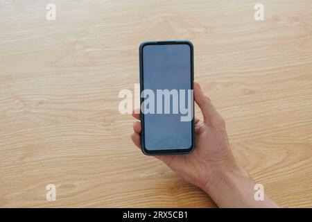 Hand of man holding smartphone with empty screen Stock Photo
