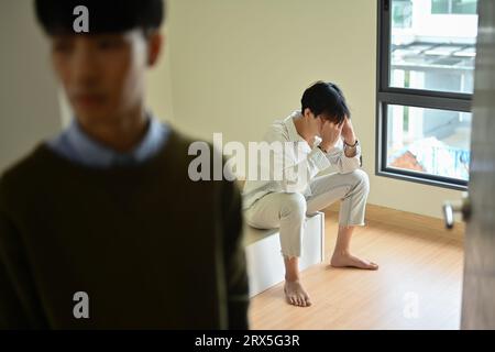 Quarreled gay male couple ignoring each other after quarreling at home.LGBTQ relationship and conflicts concept Stock Photo