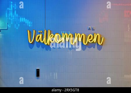 "Välkommen" (Swedish: 'welcome'), neon sign on tiled wall Stock Photo