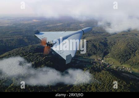 Russian military kamikaze drone Shahed flying in the clouds over mountain peyosage, Iranian combat drone in the sky, war in Ukraine, Stock Photo