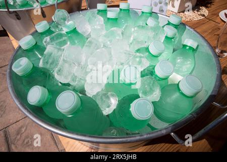 Small water bottles cooling in a zinc washbowl. Overhead view Stock Photo