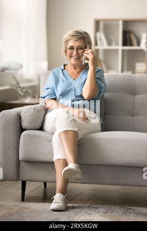 Joyful elder mature woman enjoying funny telephone conversation Stock Photo