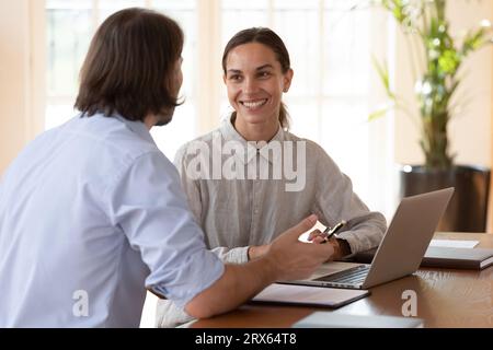 Diverse workmates discuss issues working together on project at workplace Stock Photo