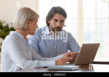 Senior businesswoman millennial businessman using laptop working together in office Stock Photo
