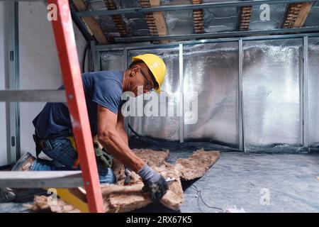 Mature construction worker working on insulation at site Stock Photo