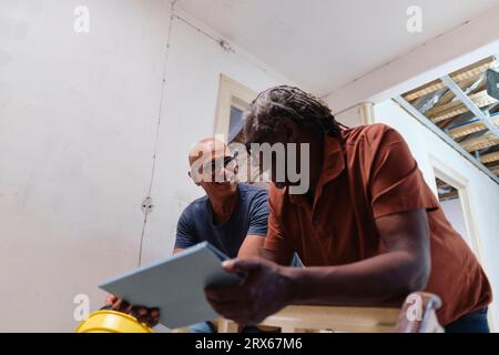 Happy architect and builder having discussion together at site Stock Photo