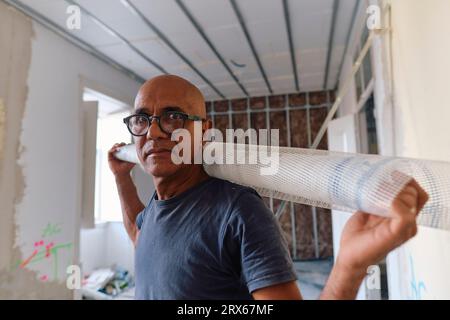 Mature construction worker standing with mesh roll at site Stock Photo