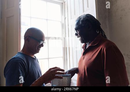 Happy architect and builder having discussion on heat insulation foils at site Stock Photo