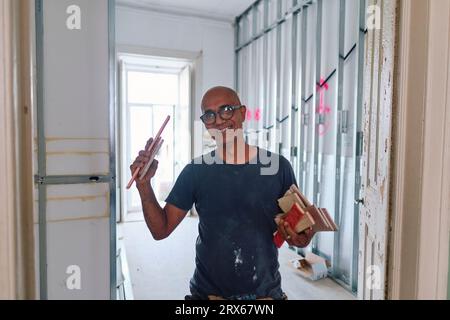Happy construction worker holding tile samples at site Stock Photo