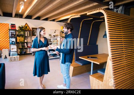 Smiling business people standing and having discussion in office Stock Photo