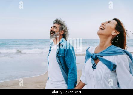 Senior couple laughing and enjoying weekend at beach Stock Photo