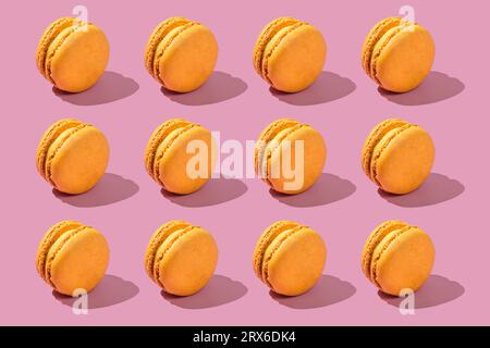 Yellow macaroons arranged on pink background Stock Photo