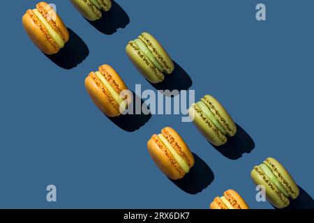 Green and yellow macaroons arranged on blue background Stock Photo
