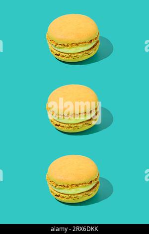 Yellow macaroons arranged in a row on colored background Stock Photo
