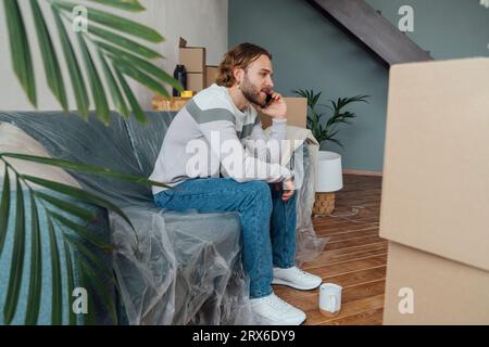 Young man talking on mobile phone at home Stock Photo