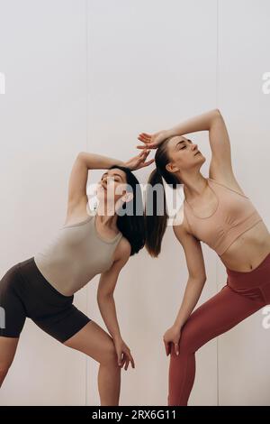 Young friends doing acroyoga with eyes closed in studio Stock Photo