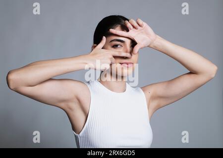 Young woman making finger frame in studio Stock Photo