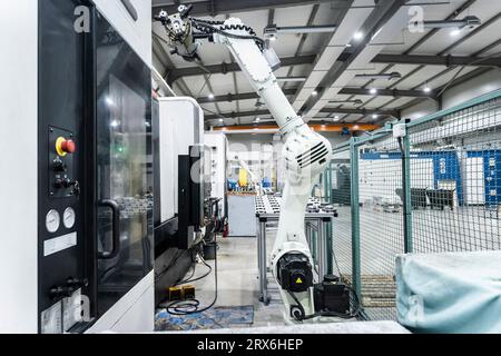 White robotic arm with cnc machinery in factory Stock Photo - Alamy