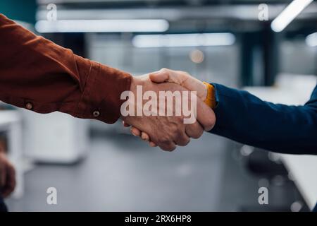Hands of business colleagues shaking hands at work place Stock Photo