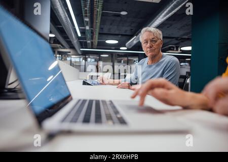 Senior businessman with eyeglasses working at desk in office Stock Photo