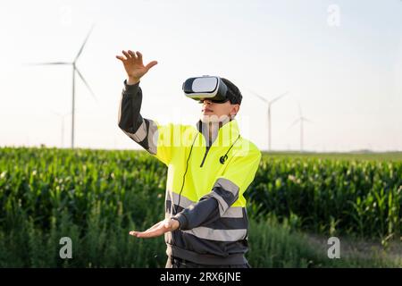 Engineer gesturing with virtual reality simulator in field Stock Photo