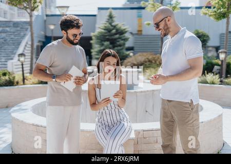 A team of architects, designers, and engineers collaborating on a city construction project. They analyze blueprints, discuss costs, and work together Stock Photo