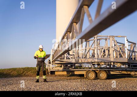 Engineer using laptop by wind turbine maintenance machine Stock Photo