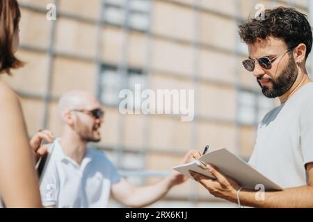A team of architects and engineers discussing blueprints and sketches for a modern urban design project. Stock Photo