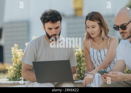 Architects and engineers collaborate outdoors, discussing a blueprint on a tablet for a modern building project. Teamwork, communication, and site ana Stock Photo