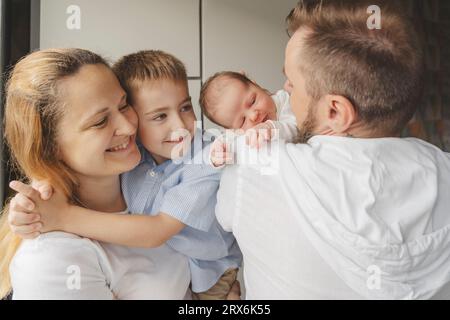 Happy parents carrying children at home Stock Photo