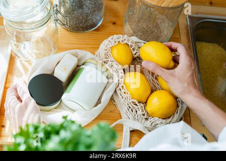 Hand of woman holding lemon at table Stock Photo