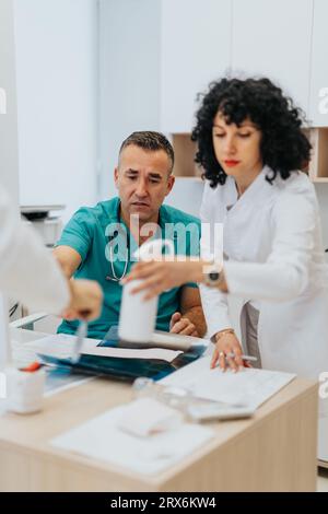 Experienced Doctor Analyzing and Explaining Health Diagnose to Young Male Patient in Clinic Stock Photo