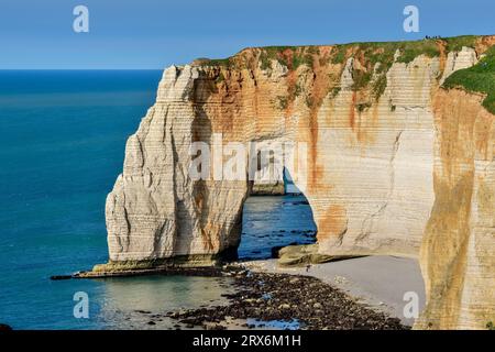 Chalk cliffs with natural arch on sunny day near blue sea Stock Photo