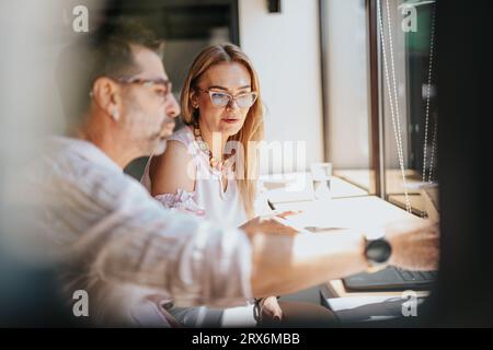 Senior business colleagues discussing project instructions, analyzing statistics, and exchanging innovative ideas for successful results in a corporat Stock Photo