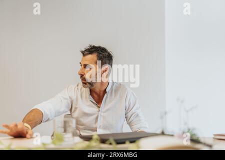 A diverse business team analyzing statistics and discussing profit growth strategies in a modern office. Stock Photo