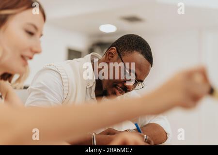 A diverse team of professionals collaborating on a business plan, analyzing data and working towards company growth in a modern office environment. Stock Photo