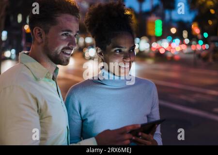Happy businesswoman and businessman with tablet PC at street Stock Photo