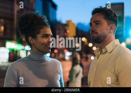 Smiling young woman looking at man Stock Photo