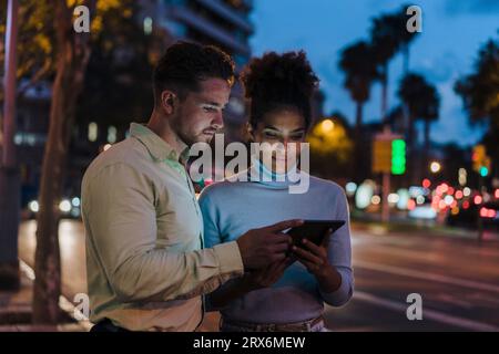 Business people discussing over tablet PC at dusk Stock Photo