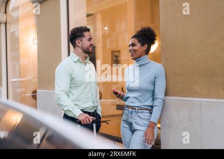 Happy businesswoman talking to colleague outside cafe Stock Photo