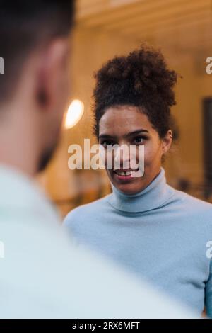 Smiling young woman looking at man Stock Photo