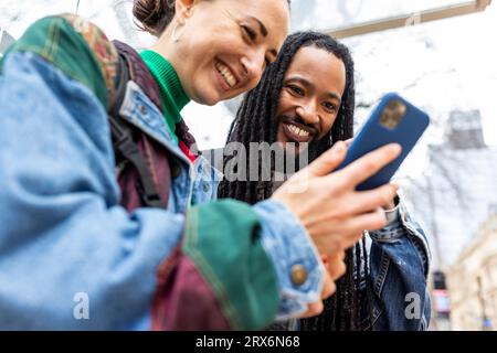 Smiling multiracial couple using smart phone Stock Photo