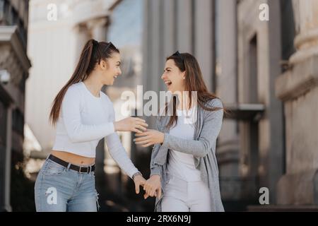 Two women standing next to each other in front of a building Stock Photo