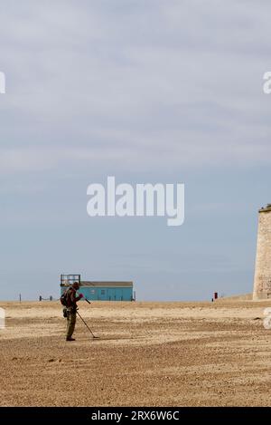 Man metal detecting along the beach at Clacton on Sea. Stock Photo