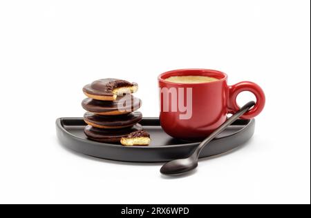 Red espresso cup filled with strong coffee and some biscuits on black dish Stock Photo